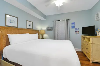 a bedroom with a white bed and a television at Majestic Beach Towers I #1105 in Panama City Beach