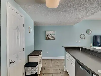 a kitchen with blue walls and a counter top at Majestic Beach Towers I #1105 in Panama City Beach
