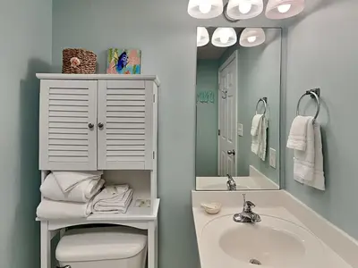 a bathroom with a sink and a toilet and a mirror at Majestic Beach Towers I #1105 in Panama City Beach