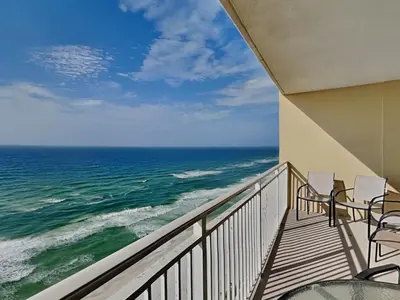 a balcony with chairs and a view of the ocean at Emerald Beach #1827 in Panama City Beach