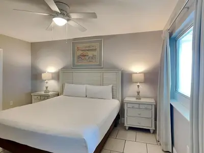 a bedroom with a white bed and two night stands at Emerald Beach #1827 in Panama City Beach
