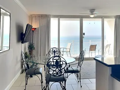 a dining room with a table and chairs and the ocean at Emerald Beach #1827 in Panama City Beach