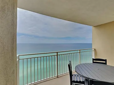 a balcony with a table and a view of the ocean at Emerald Beach #1825 in Panama City Beach