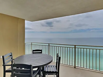a table and chairs on a balcony with the ocean at Emerald Beach #1825 in Panama City Beach