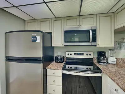 a kitchen with a white refrigerator and a microwave at Edgewater Tower II 809 in Panama City Beach