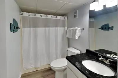 a white bathroom with a toilet and a sink at Edgewater Tower Iii 213 in Panama City Beach