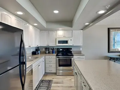 a kitchen with white cabinets and a stove top oven at Edgewater Tower Iii 213 in Panama City Beach