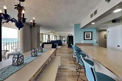 a lobby with a long bar with chairs and the ocean at Edgewater Tower Iii 213 in Panama City Beach