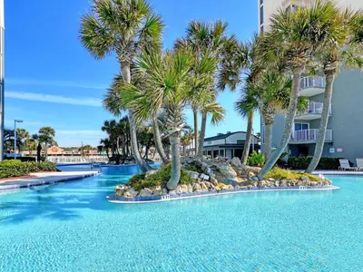 a swimming pool with palm trees in a resort at Long Beach Resort Tower IV #407 in Panama City Beach