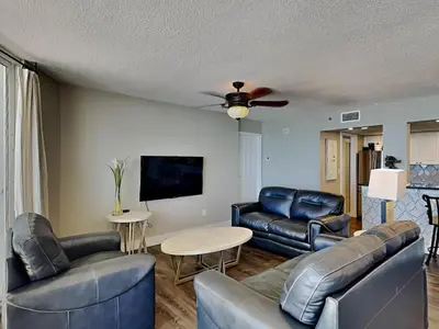 a living room with leather furniture and a ceiling fan at Long Beach Resort Tower I #503 in Panama City Beach
