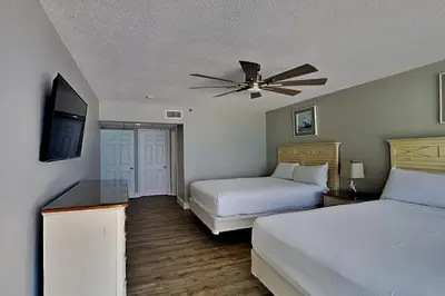 a bedroom with two beds and a flat screen tv at Long Beach Resort Tower II #503 in Panama City Beach