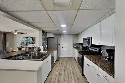 a large kitchen with white cabinets and a sink at Long Beach Resort Tower II #503 in Panama City Beach