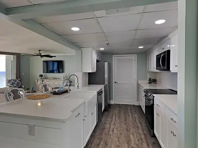a large kitchen with white cabinets and a sink at Long Beach Resort Tower I #900 in Panama City Beach