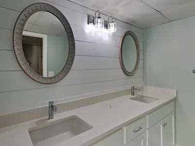 a bathroom with two sinks and two mirrors at Long Beach Resort Tower I #900 in Panama City Beach