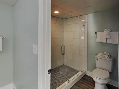 a bathroom with a toilet and a glass shower at Long Beach Resort Tower I #900 in Panama City Beach