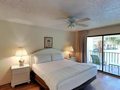 a bedroom with a large bed and a balcony at Edgewater Villa #814 in Panama City Beach