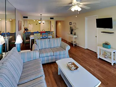 a living room with two couches and a tv at Edgewater Villa #814 in Panama City Beach