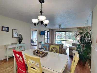 a dining room with a white table and chairs at Edgewater Villa #814 in Panama City Beach