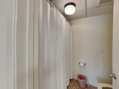 a bathroom with a shower with a white shower curtain at Edgewater Villa #814 in Panama City Beach