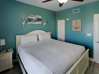 a bedroom with a large bed with blue walls at Shores of Panama #1425 in Panama City Beach