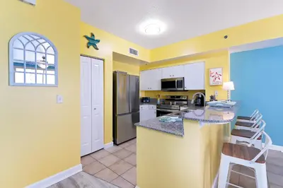 a kitchen with yellow walls and a counter top at Shores of Panama #1425 in Panama City Beach