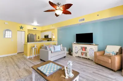 a living room with a couch and a tv at Shores of Panama #1425 in Panama City Beach