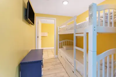 a room with two bunk beds and a television at Shores of Panama #1425 in Panama City Beach