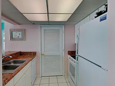 a kitchen with a sink and a refrigerator at Long Beach Resort Tower II #702 in Panama City Beach