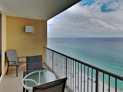 a balcony with a table and chairs and the ocean at Majestic Beach Towers I #2005 in Panama City Beach