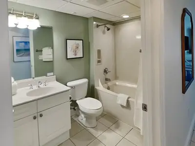 a bathroom with a sink and a toilet and a bath tub at Emerald Beach #1934 in Panama City Beach