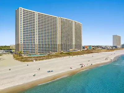 a large building on a beach next to the ocean at Emerald Beach #1934 in Panama City Beach