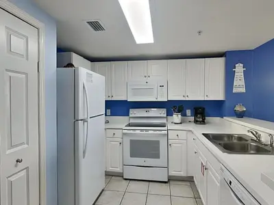 a kitchen with white appliances and blue walls at Majestic Beach Towers I #1703 in Panama City Beach