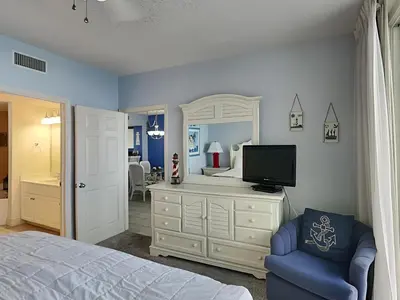 a bedroom with a bed and a tv and a mirror at Majestic Beach Towers I #1703 in Panama City Beach