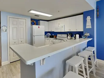 a kitchen with white appliances and blue walls at Majestic Beach Towers I #1703 in Panama City Beach