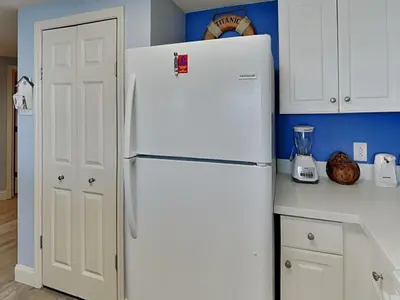 a white refrigerator in a kitchen with blue walls at Majestic Beach Towers I #1703 in Panama City Beach
