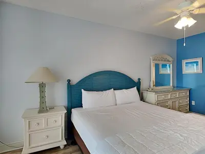 a bedroom with a bed and a blue wall at Majestic Beach Towers II #1106 in Panama City Beach