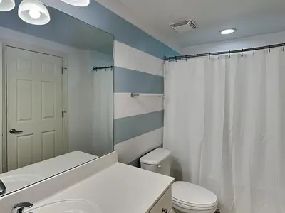 a bathroom with a white toilet and a white shower curtain at Majestic Beach Towers II #1106 in Panama City Beach