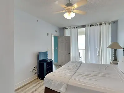 a bedroom with a bed and a ceiling fan at Majestic Beach Towers II #1106 in Panama City Beach