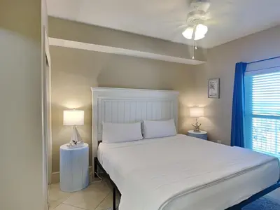 a bedroom with a white bed and two lamps at Majestic Beach Towers I #1311 in Panama City Beach