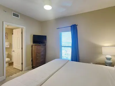 a bedroom with a bed and a television and a window at Majestic Beach Towers I #1311 in Panama City Beach