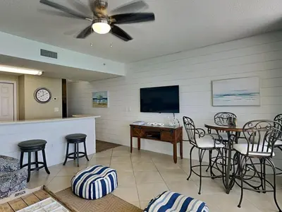 a living room with a tv and a table and chairs at Majestic Beach Towers I #1311 in Panama City Beach