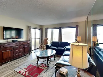 a living room with a couch and a tv at Edgewater Villa #902 in Panama City Beach