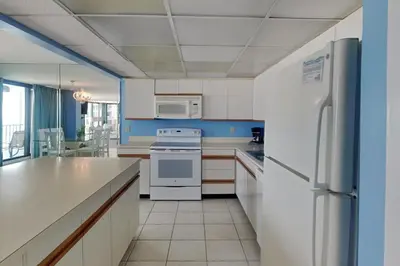 a kitchen with white appliances and blue walls at Edgewater Tower III #302 in Panama City Beach