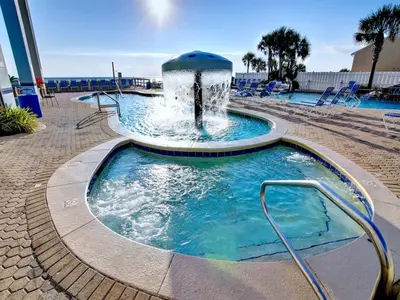 a swimming pool with a fountain in a resort at Majestic Beach Towers I #207 in Panama City Beach