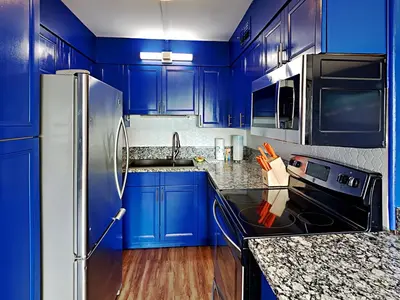 a kitchen with blue cabinets and a stainless steel refrigerator at Summit Beach Resort 430 in Panama City Beach