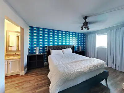 a bedroom with a bed and a blue wall at Summit Beach Resort 430 in Panama City Beach
