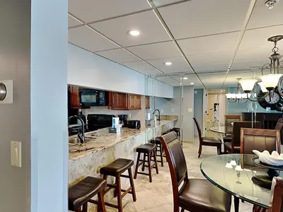 a kitchen and dining room with a bar and chairs at Edgewater Tower III #212 in Panama City Beach