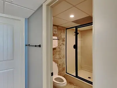 a bathroom with a toilet and a glass shower at Edgewater Tower III #212 in Panama City Beach