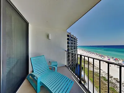 a blue chair sitting on a balcony overlooking the beach at Edgewater Tower II 909 in Panama City Beach