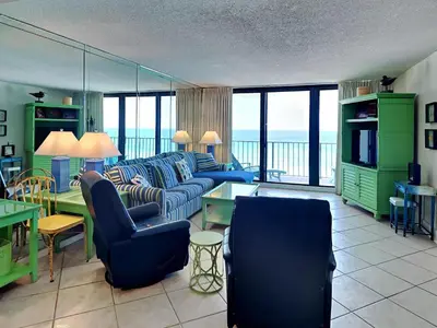 a living room with blue furniture and a view of the ocean at Edgewater Tower II 909 in Panama City Beach